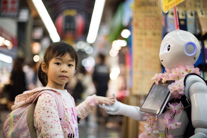 Child shakes hand with robot